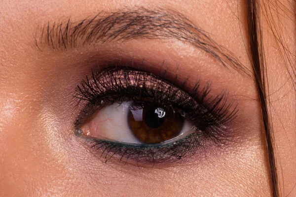 Büyük profesyonel makyaj gözleri. Glitter, göz farı, fosforlu kalem, göz kalemi. Kız yakın çekim göz.