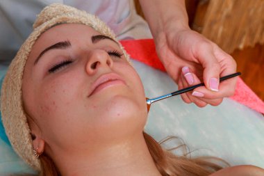 Güzellik bakımları için sorun cilt. Krem uygulamak kız spa salonda.