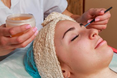 Güzellik bakımları için sorun cilt. Krem uygulamak kız spa salonda.