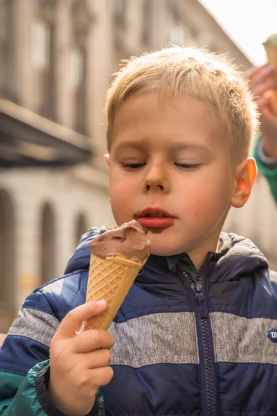 Chłopiec zjada lody na ulicach — Zdjęcie stockowe