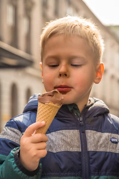 Chłopiec zjada lody na ulicach — Zdjęcie stockowe