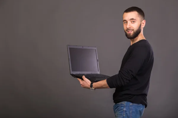 Elegante y exitoso hombre de negocios con una computadora portátil —  Fotos de Stock