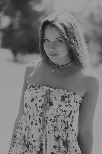 Mujer morena joven en un vestido blanco. Una chica está parada en medio del campo de flores rosadas en un día soleado. Campo, flores belleza, naturaleza, - El concepto de vacaciones en el campo. Artículo sobre vacaciones . —  Fotos de Stock