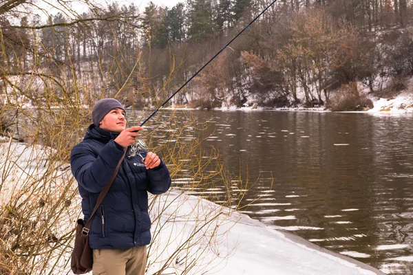 Il pescatore pesca su un inverno filante — Foto Stock