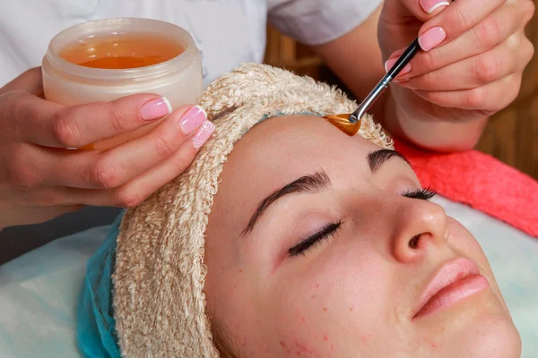 Tratamientos de belleza para piel problemática. La chica en el salón de spa, aplicando crema . — Foto de Stock