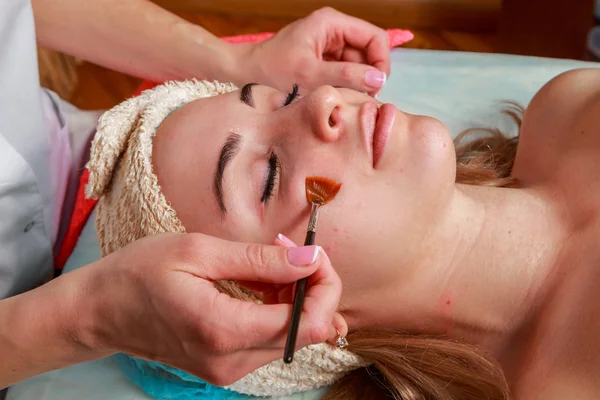 Trattamenti di bellezza per la pelle problematica. La ragazza nel salone termale, applicando la crema . — Foto Stock