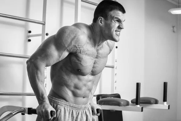 Un hombre muy fuerte se dedica al gimnasio —  Fotos de Stock