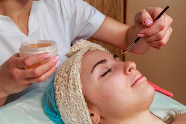 Tratamentos de beleza para a pele problema. A menina no salão de spa, aplicando creme . — Fotografia de Stock