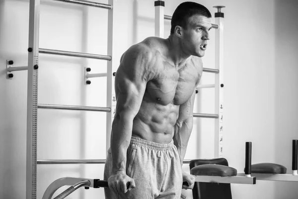 A very strong man is engaged in the gym — Stock Photo, Image