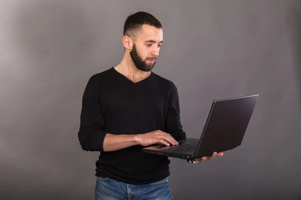 Elegante y exitoso hombre de negocios con una computadora portátil —  Fotos de Stock