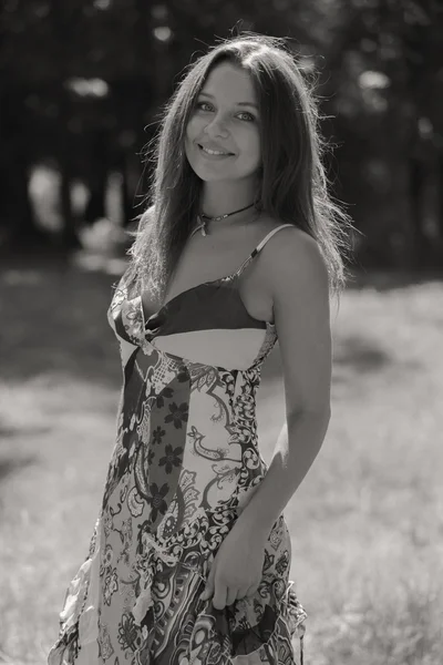 Jeune femme brune en robe blanche. Une fille se tient au milieu du champ de fleurs roses par une journée ensoleillée. Champ, fleurs beauté, nature, - Le concept de vacances à la campagne. Article sur les vacances . — Photo