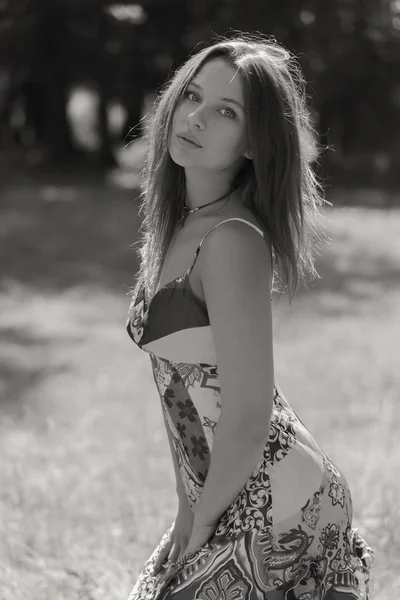 Mujer morena joven en un vestido blanco. Una chica está parada en medio del campo de flores rosadas en un día soleado. Campo, flores belleza, naturaleza, - El concepto de vacaciones en el campo. Artículo sobre vacaciones . — Foto de Stock