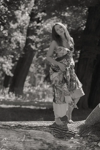 Giovane donna bruna in un vestito bianco. Una ragazza si trova in mezzo al campo di fiori rosa in una giornata di sole. Campo, la bellezza dei fiori, la natura, - Il concetto di vacanza in campagna. Articolo sulle vacanze . — Foto Stock