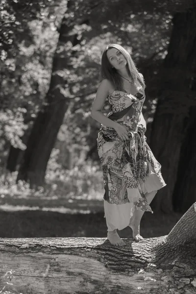 Mulher morena jovem em um vestido branco. Uma menina fica no meio do campo de flores cor-de-rosa em um dia ensolarado. Campo, flores beleza, natureza, - O conceito de férias no campo. Artigo sobre férias . — Fotografia de Stock