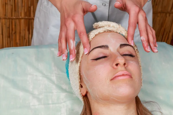 Chica con una esteticista en el salón de spa. esteticista realiza procedimientos cosméticos. Aplicación de crema cosmética. Cosmetología, facial, belleza - El concepto de cuidado de la piel facial. Artículo sobre cosmetología . — Foto de Stock