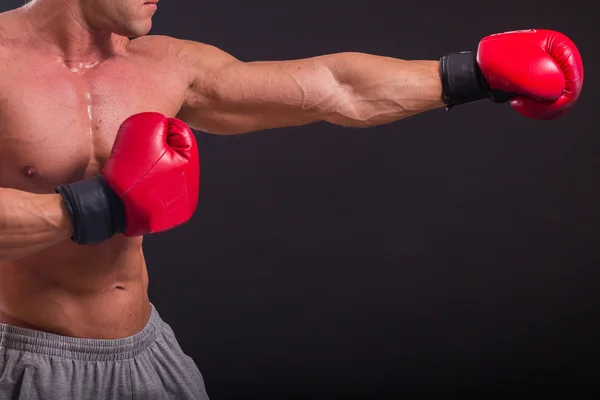 Bodybuilder poserar i olika poser visar sina muskler. Fel på en mörk bakgrund. Manliga visar musklerna spännare. Vackra muskulös kropp idrottsman nen. — Stockfoto