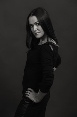 Karanlık bir arka plan üzerinde güzel, gizemli, şirin esmer. Siyah ve beyaz fotoğraf güzel gizemli esmer.