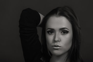 Karanlık bir arka plan üzerinde güzel, gizemli, şirin esmer. Siyah ve beyaz fotoğraf güzel gizemli esmer.