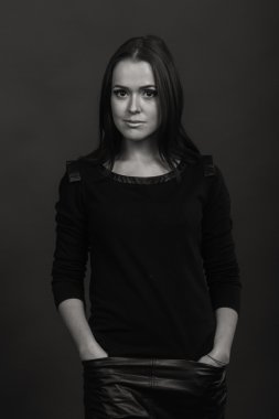 Karanlık bir arka plan üzerinde güzel, gizemli, şirin esmer. Siyah ve beyaz fotoğraf güzel gizemli esmer.