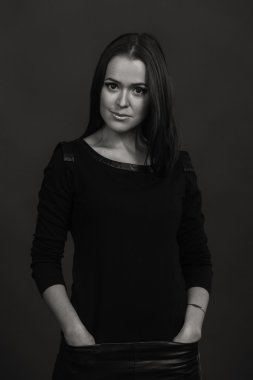 Karanlık bir arka plan üzerinde güzel, gizemli, şirin esmer. Siyah ve beyaz fotoğraf güzel gizemli esmer.