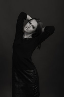 Karanlık bir arka plan üzerinde güzel, gizemli, şirin esmer. Siyah ve beyaz fotoğraf güzel gizemli esmer.