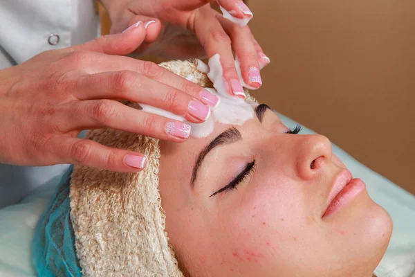 Beauty treatments for problem skin. The girl in the spa salon, applying cream. — Stock Photo, Image