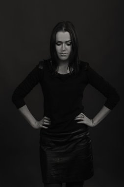 Karanlık bir arka plan üzerinde güzel, gizemli, şirin esmer. Siyah ve beyaz fotoğraf güzel gizemli esmer.