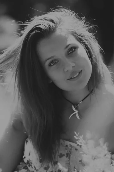 Mujer morena joven en un vestido blanco. Una chica está parada en medio del campo de flores rosadas en un día soleado. Campo, flores belleza, naturaleza, - El concepto de vacaciones en el campo. Artículo sobre vacaciones . —  Fotos de Stock