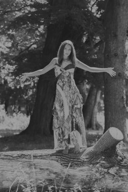 Beyaz elbiseli genç esmer kadın. Bir kız, güneşli bir günde pembe çiçekler tarlanın ortasında duruyor. Alan, çiçekler güzellik, doğa, - ülke tatil kavramı. Tatil hakkında makale.