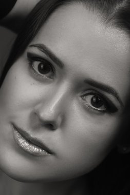 Karanlık bir arka plan üzerinde güzel, gizemli, şirin esmer. Siyah ve beyaz fotoğraf güzel gizemli esmer.