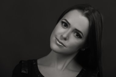 Karanlık bir arka plan üzerinde güzel, gizemli, şirin esmer. Siyah ve beyaz fotoğraf güzel gizemli esmer.