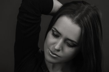 Karanlık bir arka plan üzerinde güzel, gizemli, şirin esmer. Siyah ve beyaz fotoğraf güzel gizemli esmer.