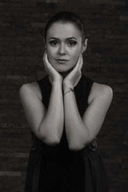 Karanlık bir arka plan üzerinde güzel, gizemli, şirin esmer. Siyah ve beyaz fotoğraf güzel gizemli esmer.