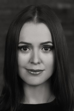 Karanlık bir arka plan üzerinde güzel, gizemli, şirin esmer. Siyah ve beyaz fotoğraf güzel gizemli esmer.