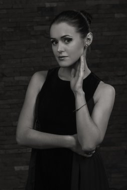 Karanlık bir arka plan üzerinde güzel, gizemli, şirin esmer. Siyah ve beyaz fotoğraf güzel gizemli esmer.