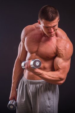 Bir adam siyah dumbbells ile