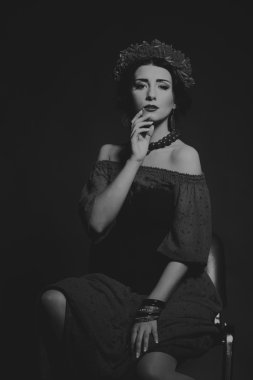 Karanlık bir arka plan üzerinde güzel, gizemli, şirin esmer. Siyah ve beyaz fotoğraf güzel gizemli esmer.