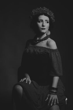 Karanlık bir arka plan üzerinde güzel, gizemli, şirin esmer. Siyah ve beyaz fotoğraf güzel gizemli esmer.