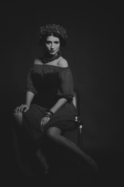 Karanlık bir arka plan üzerinde güzel, gizemli, şirin esmer. Siyah ve beyaz fotoğraf güzel gizemli esmer.