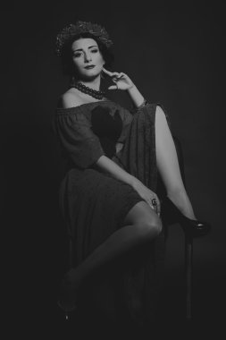 Karanlık bir arka plan üzerinde güzel, gizemli, şirin esmer. Siyah ve beyaz fotoğraf güzel gizemli esmer.