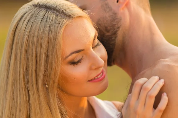 Man och kvinna omfamnar ömt i fältet. Kärlek och uppriktiga känslor. Vackra unga par. Foto för sociala tidskrifter, affischer och webbplatser. — Stockfoto