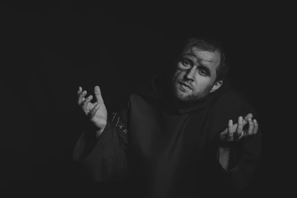 Beautiful and fascinating game theater actor on camera. Black and white photo of the actor in the guise of a beggar on a dark background. Beautifully decorated stage image and professional makeup.