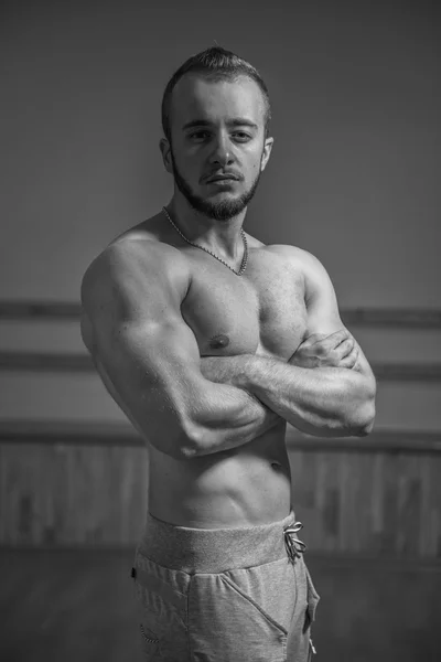 Foto van een man in de sportschool. Beeld een man in een fitnesscentrum met fitnessapparaten. — Stockfoto