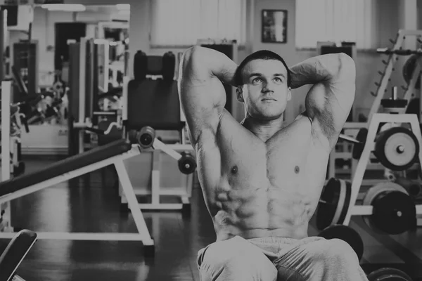 Un hombre muy fuerte se dedica al gimnasio — Foto de Stock