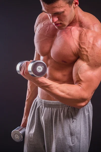 Bir adam siyah dumbbells ile