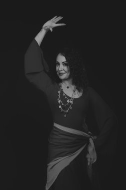 Karanlık bir arka plan üzerinde güzel, gizemli, şirin esmer. Siyah ve beyaz fotoğraf güzel gizemli esmer.