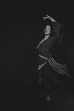 Karanlık bir arka plan üzerinde güzel, gizemli, şirin esmer. Siyah ve beyaz fotoğraf güzel gizemli esmer.