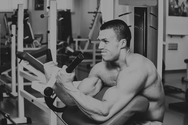 Athlète dans la salle de gym faisant poussée verticale. Le pouvoir d'exercer les muscles du dos. Photos pour magazines sportifs, affiches et sites web . — Photo