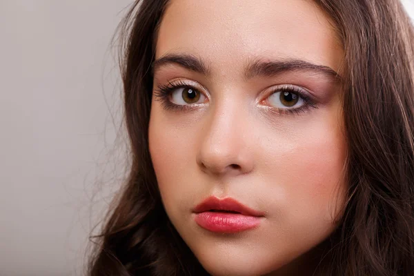 Retrato de una hermosa morena sobre un fondo claro. Cabello elegante, ojos y cejas . —  Fotos de Stock