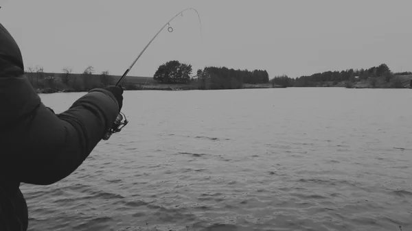 Muž s rotující na jezeře. Rybaření — Stock fotografie